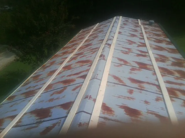 Rusted metal roof panels with new wood purlins before replacement — Storm Damage Roof Repair in New Roads by Roofing Brothers