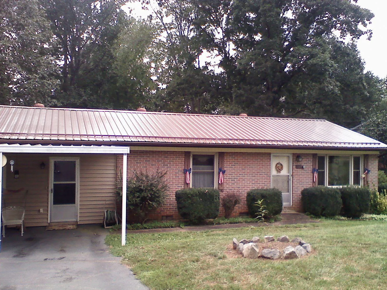 Bronze metal roof and carport on a brick ranch home — Roof Repair work by our crew in New Roads